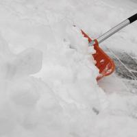 Someone shoveling snow with an orange shovel
